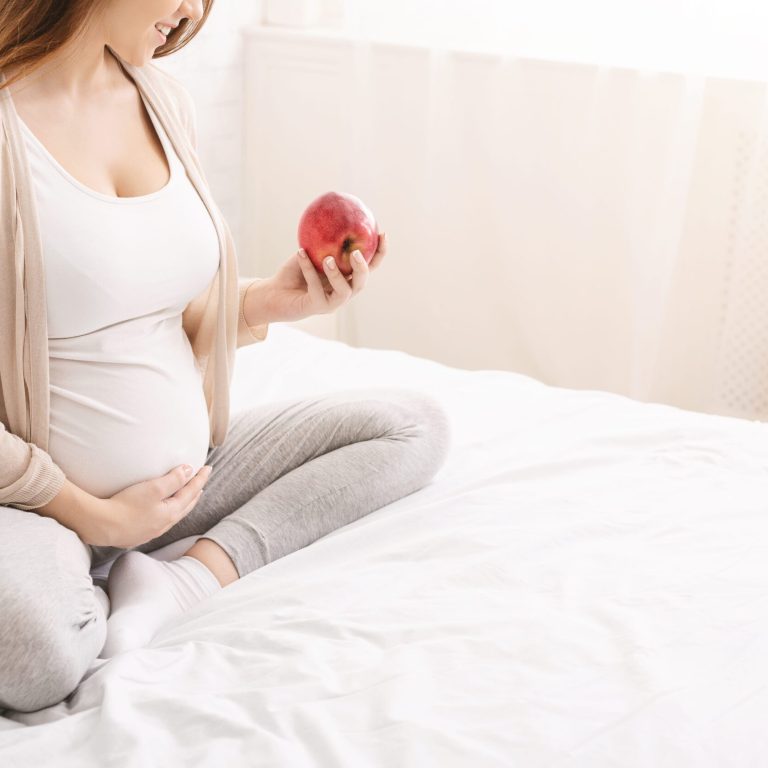 young-pregnant-woman-eating-red-apple-in-bed-at-ho-2026-01-08-23-08-53-utc (1)